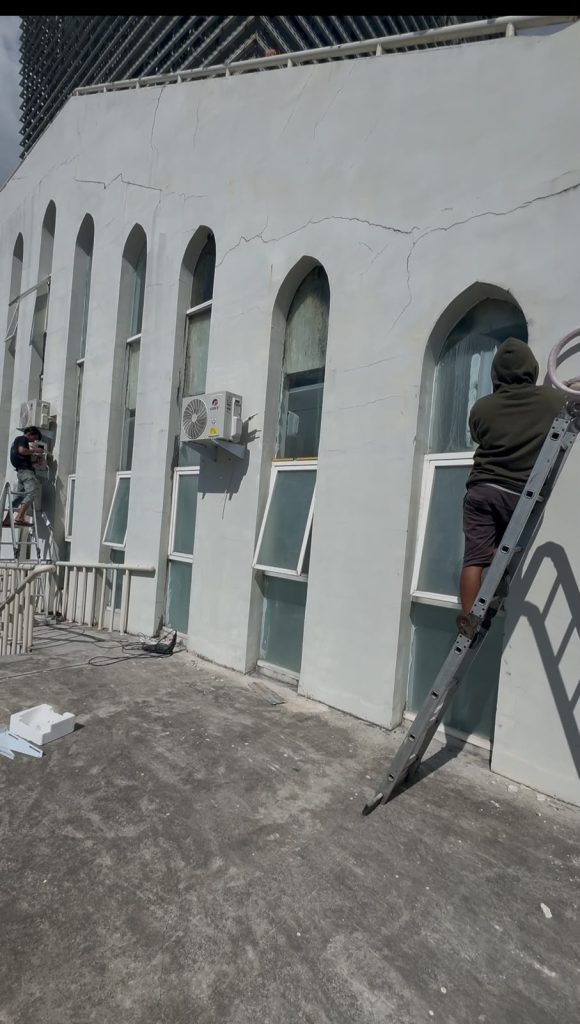 Aktivitas teknisi dan unit outdoor pada sisi bangunan